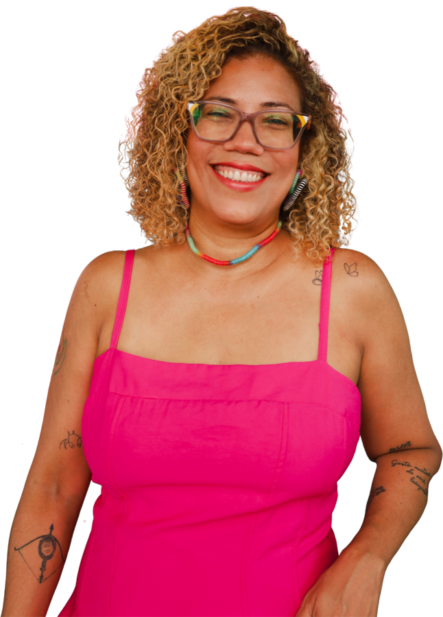 Dra. Taís Matos, sorrindo, de óculos e vestido rosa.
